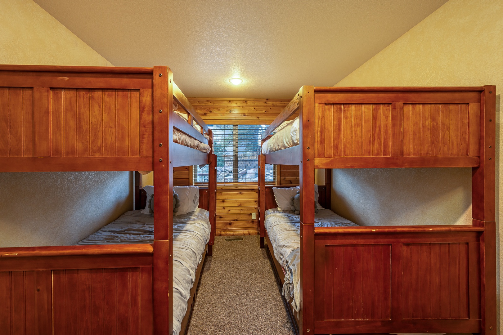 Cozy bunk room with rich wood finishes sleeps four comfortably, perfect for families or groups sharing mountain adventures together.