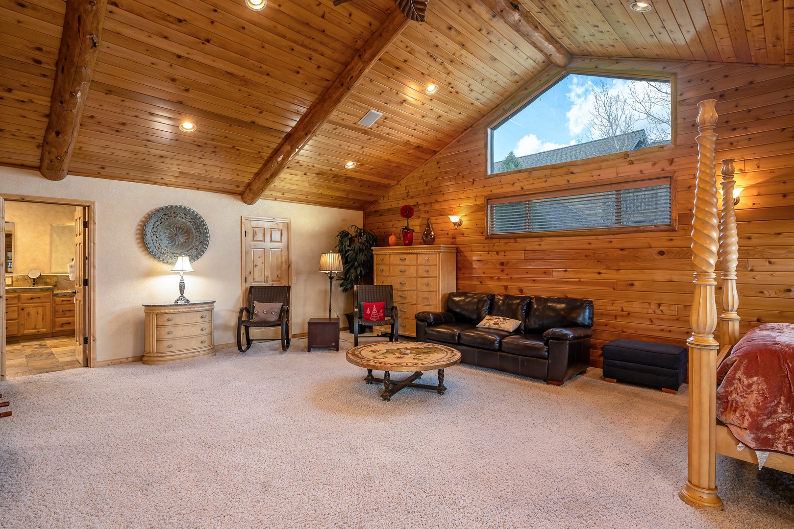 Relax in your spacious loft retreat with soaring wood-beam ceilings and leather seating area, where natural light streams through skylights above your cozy hideaway.