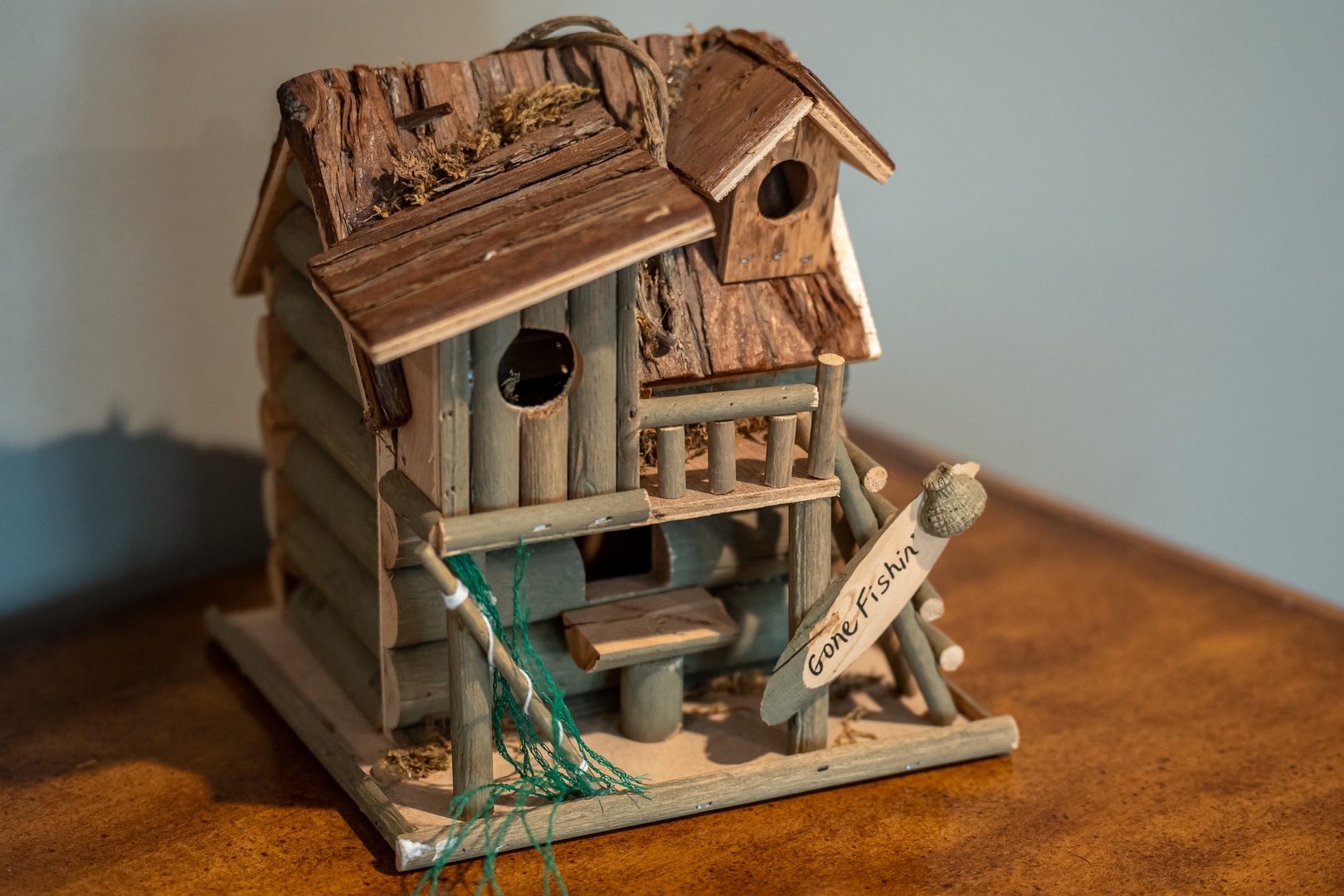 Charming handcrafted birdhouse brings rustic lakeside character to your vacation retreat, adding a whimsical decorative touch.