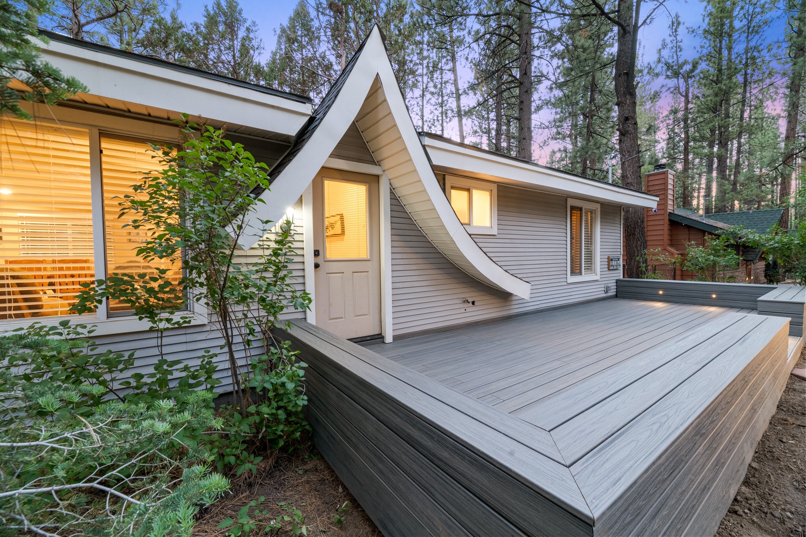 This A-frame cabin nestled among towering pines offers a peaceful forest retreat. The wraparound deck creates the perfect spot to unwind after exploring nearby trails.