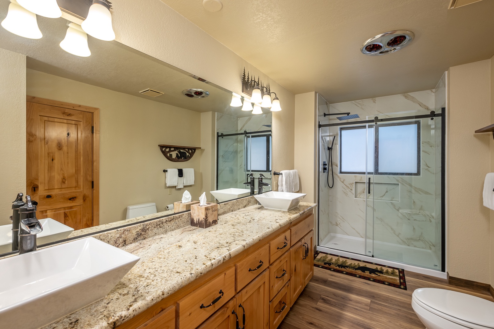 Step into your spacious bathroom with dual vanities, elegant granite countertops, and a luxurious marble-tiled walk-in shower—your private retreat after mountain adventures.
