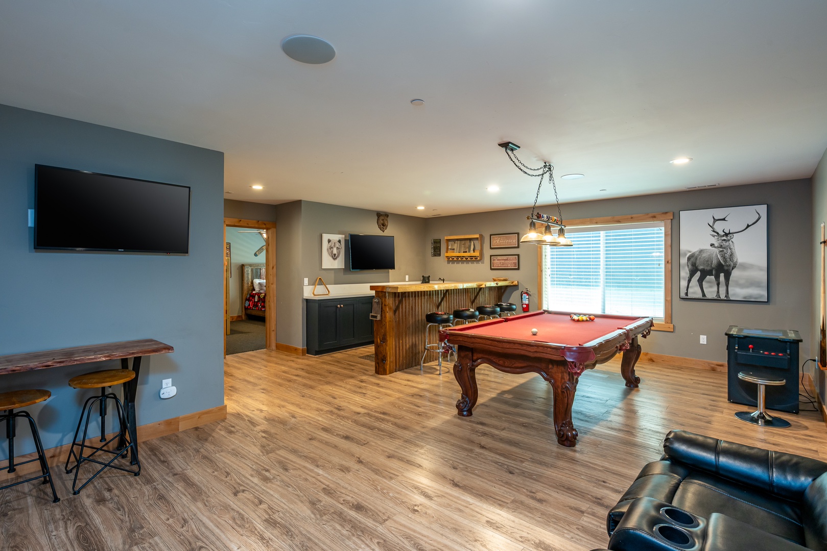 Your own private game room awaits with a pool table, bar seating, arcade game, and cozy lounge area—perfect for friendly competition and laid-back evenings.