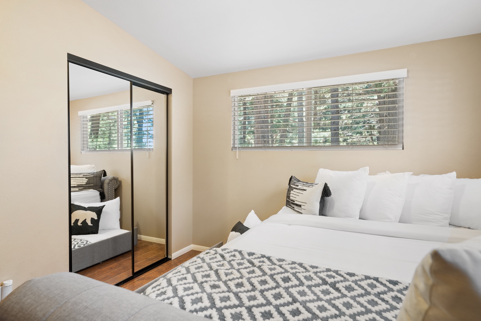Soft natural light fills your peaceful bedroom retreat, where crisp linens await and a mirrored wardrobe adds spaciousness to your cozy haven.