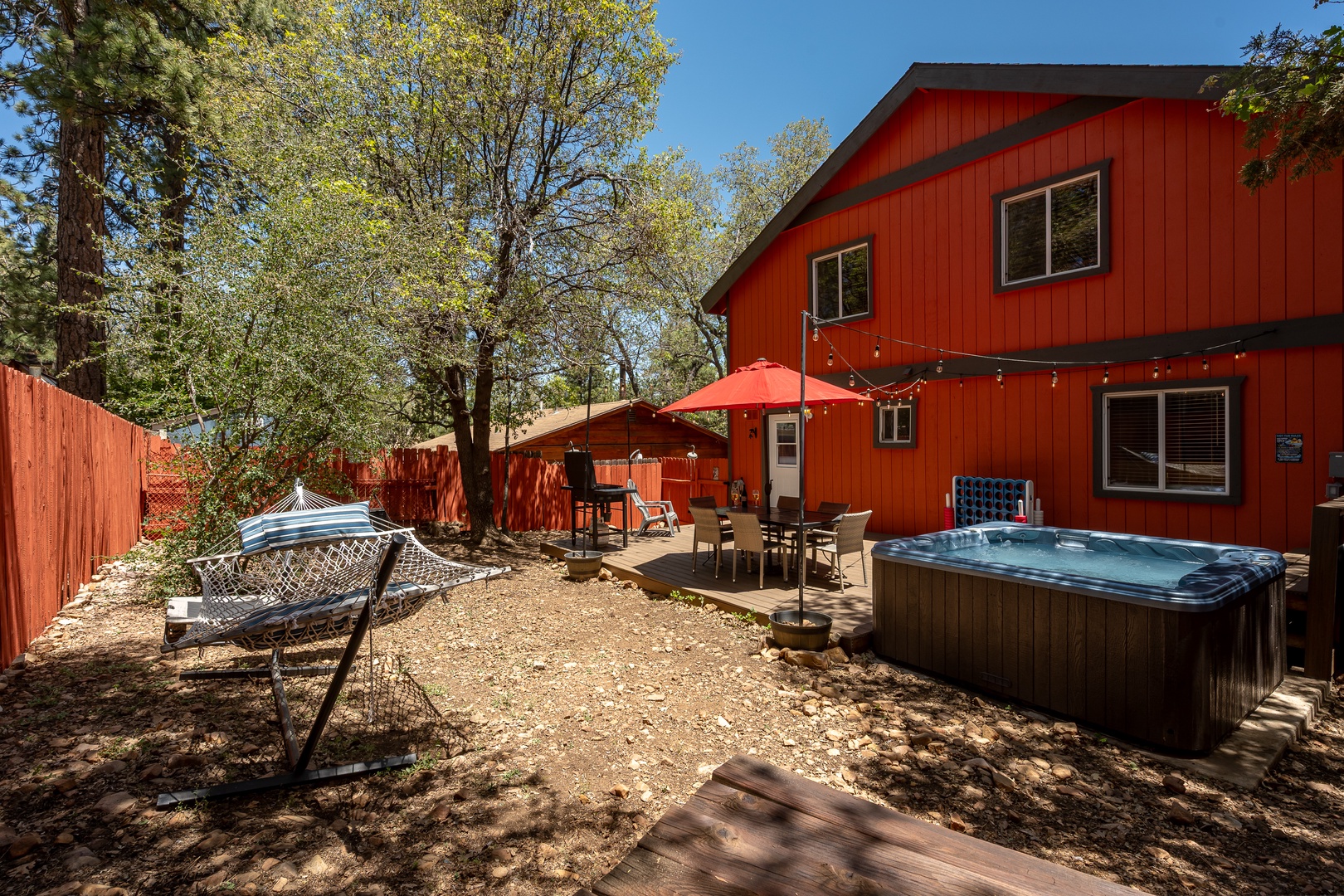 Soak in the bubbling hot tub under the trees, lounge in the hammock, or gather around the patio table—your private backyard oasis awaits.