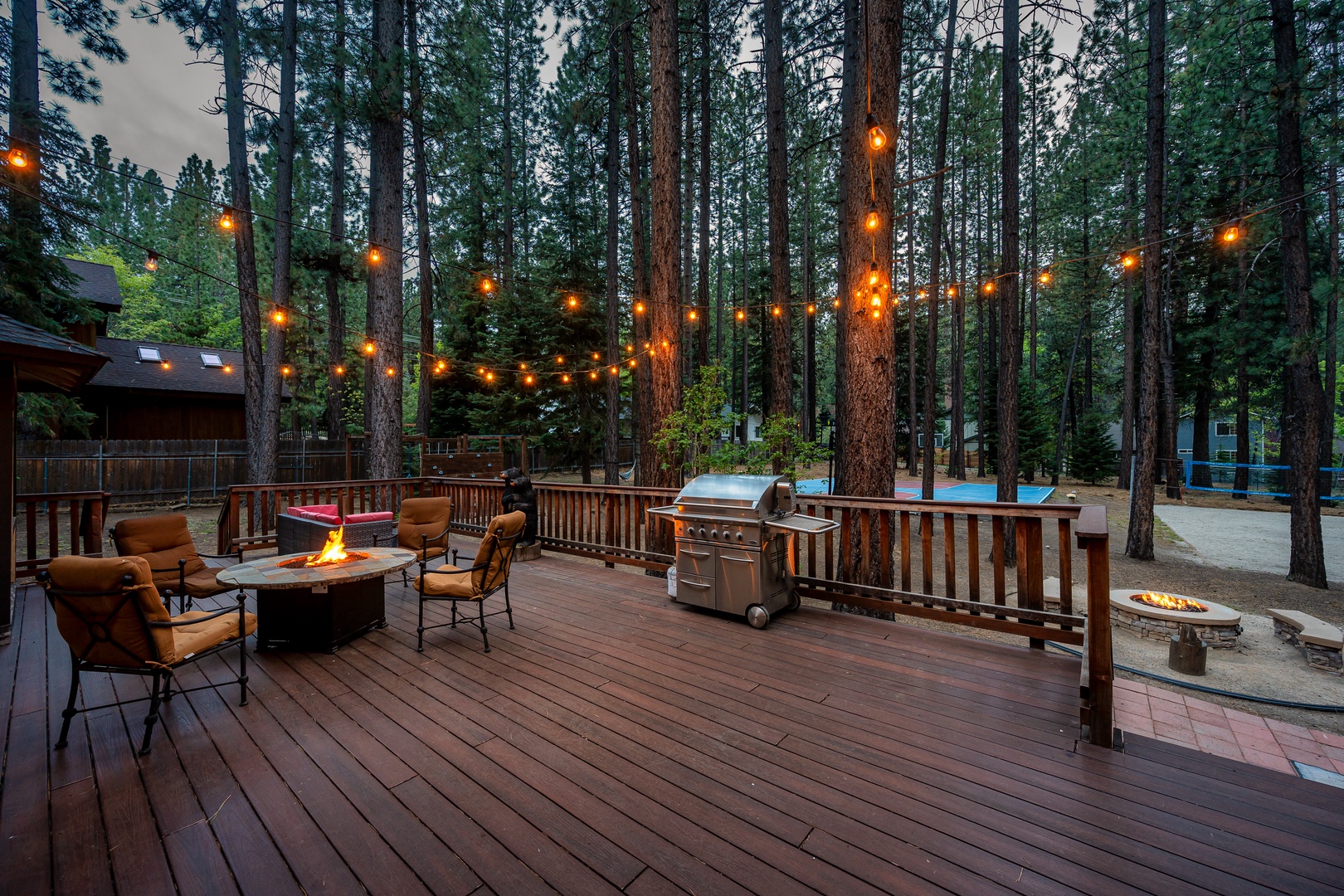 Gather under twinkling string lights on your private deck, surrounded by towering pines. Perfect for grilling, relaxing by the fire pit, or enjoying peaceful mountain evenings.