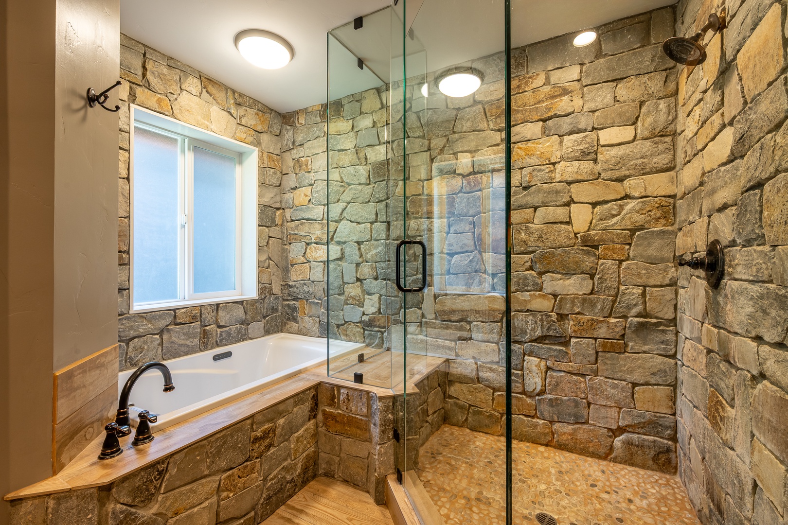 Unwind in your private spa, where rustic stone walls meet modern luxury. Soak in the tub or refresh in the spacious glass-enclosed shower after a day of adventure!