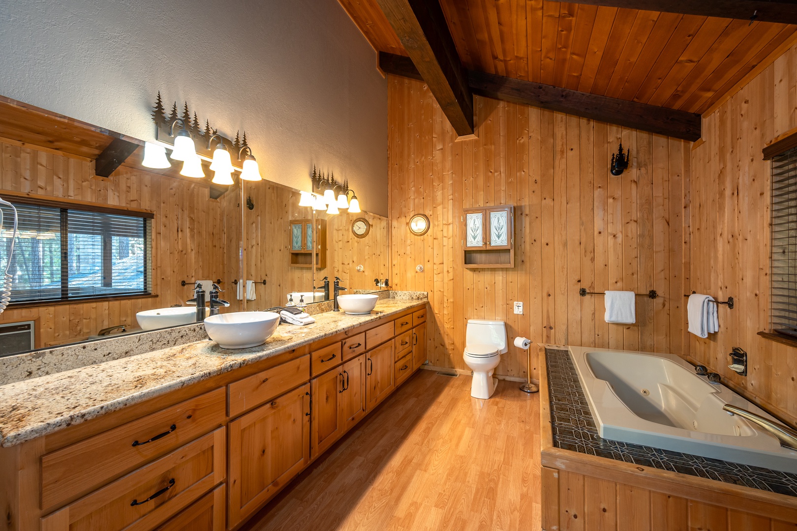 Sink into relaxation in your private bathroom, where warm wood and granite finishes blend with a spacious soaking tub, perfect for unwinding after your mountain adventures.