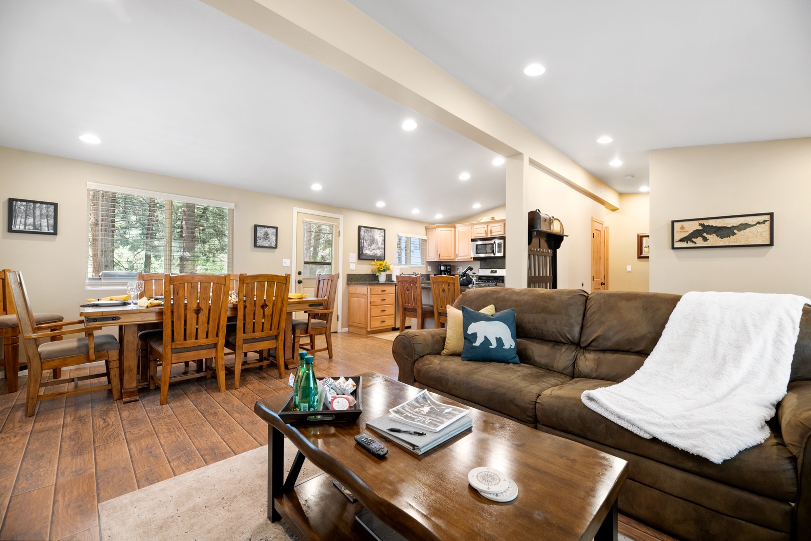 Unwind in this inviting open-concept space where natural light streams through large windows. Sink into the plush sofa, gather around the dining table, or prepare meals in the fully equipped kitchen—all while staying connected with your group.