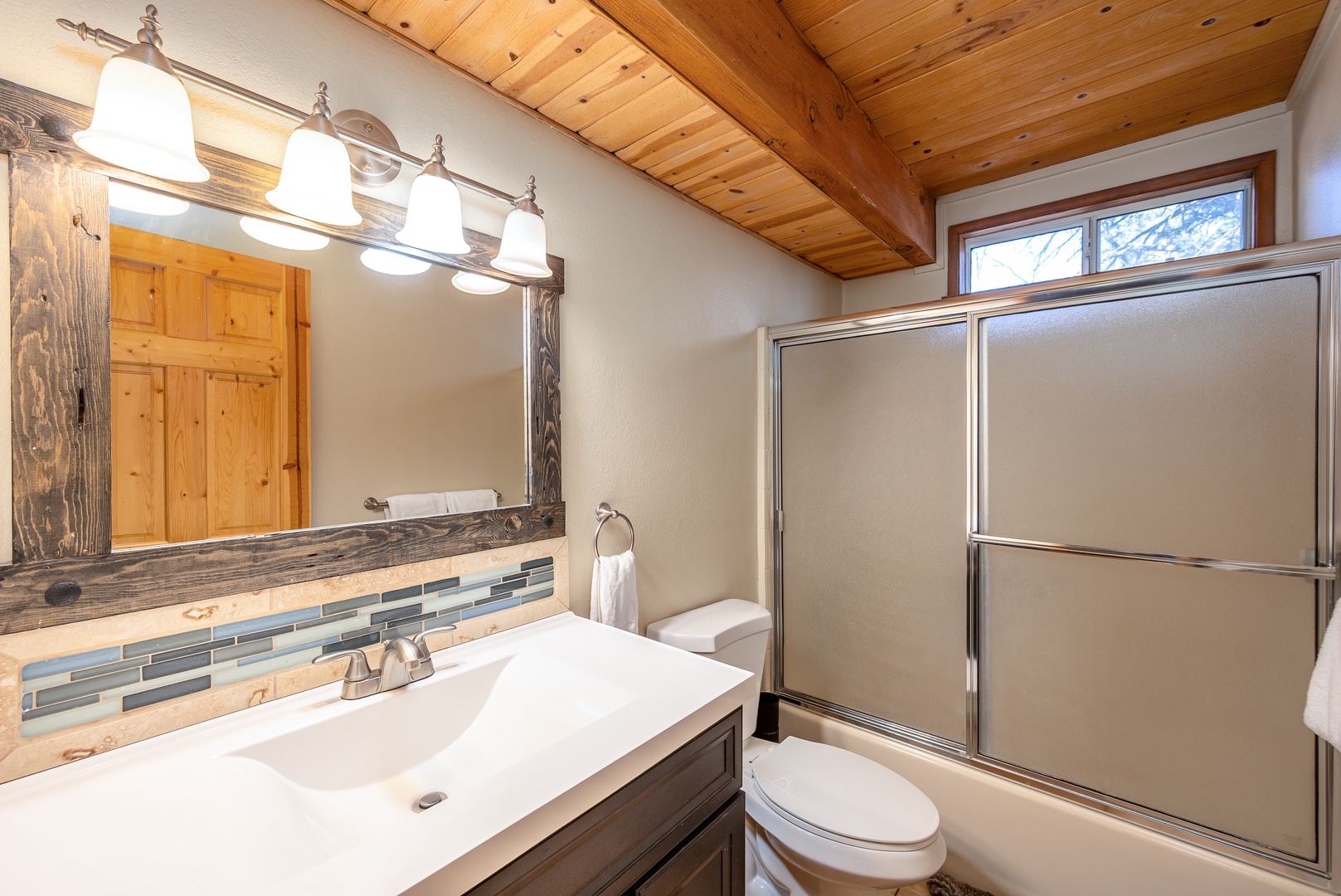 Unwind in your stylish bathroom with rustic charm, featuring exposed beam ceilings and a spacious shower for ultimate relaxation.