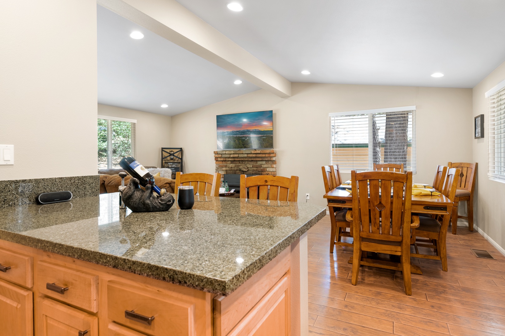 Gather around the spacious dining table after cooking together in your well-equipped kitchen. The open layout and cozy fireplace create the perfect atmosphere for memorable meals and quality time with loved ones.