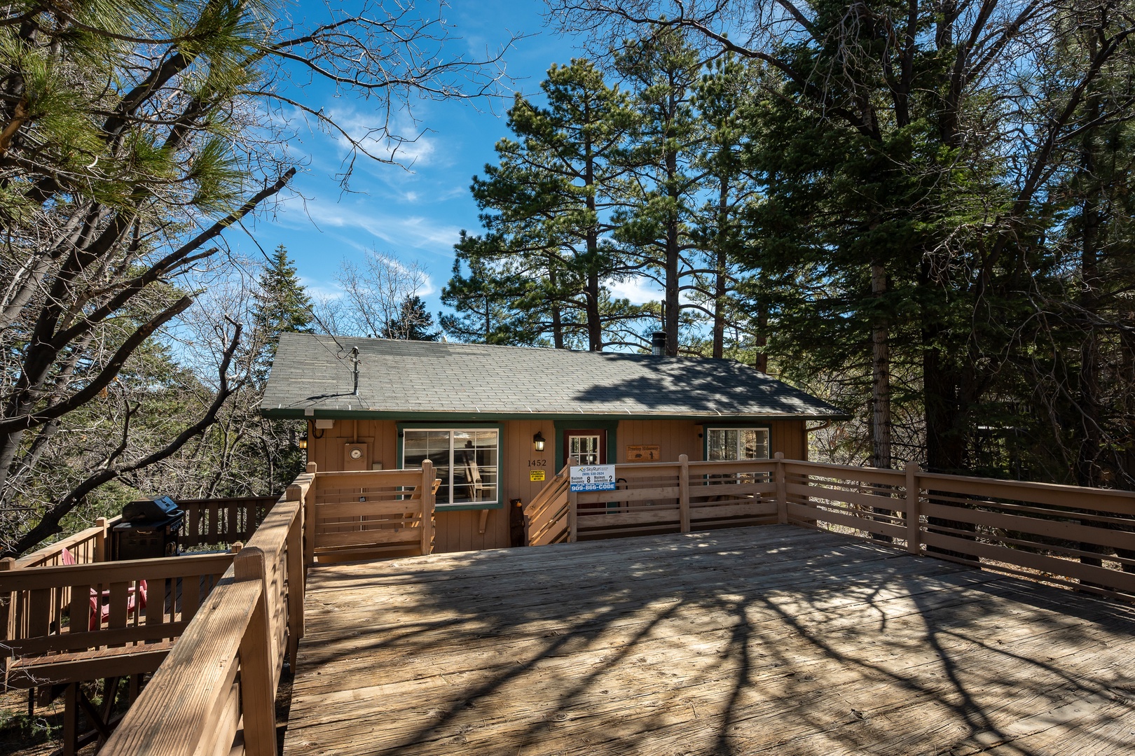 Rustic mountain cabin surrounded by towering pines offers a peaceful forest retreat with expansive wooden deck for relaxation.