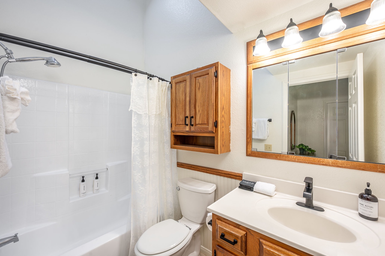 A skylight fills a full-size bathtub with shower with sunlight. Cabinetry awaits your essentials.