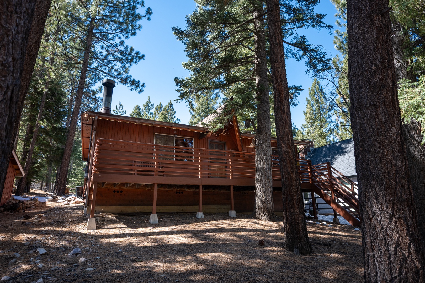 Charming wood cabin nestled among towering pines creates a peaceful mountain escape. The elevated deck and natural surroundings promise tranquil mornings and relaxing forest views throughout your stay.