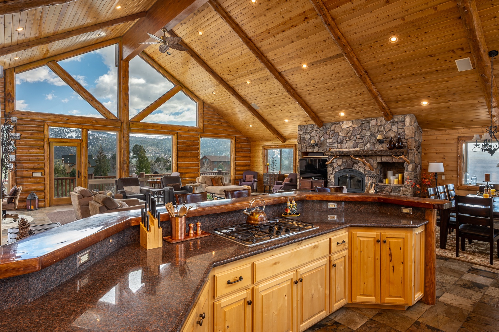 Rustic elegance meets modern comfort in your open-concept living space, where soaring wood ceilings and mountain views create the perfect backdrop for memorable gatherings.