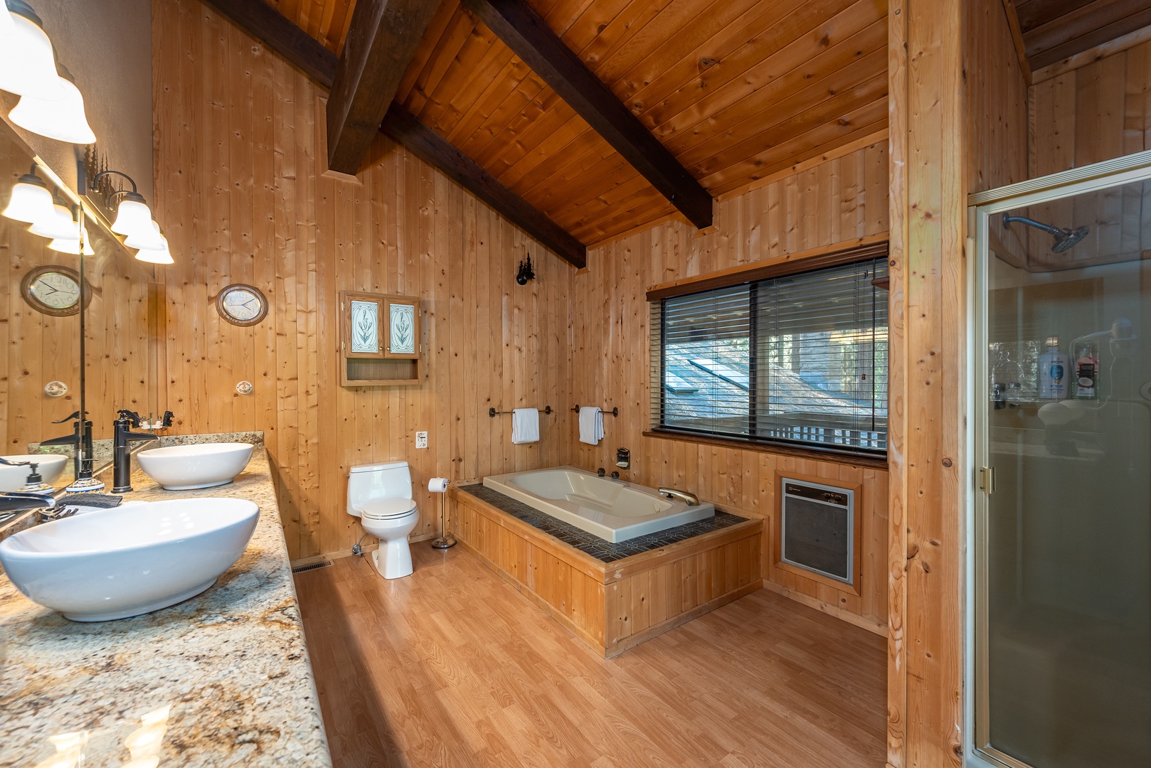 Relax in your private spa-like bathroom with soaking tub, dual vessel sinks, and warm wood finishes throughout.