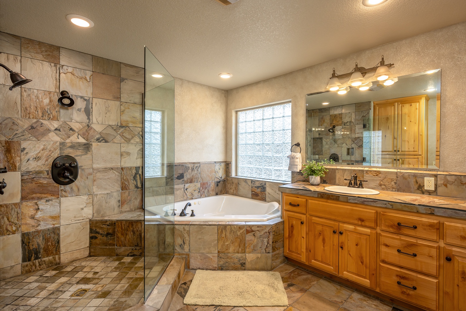 Unwind in your luxurious spa-like bathroom with marble finishes, separate soaking tub, and spacious walk-in shower after adventurous days.