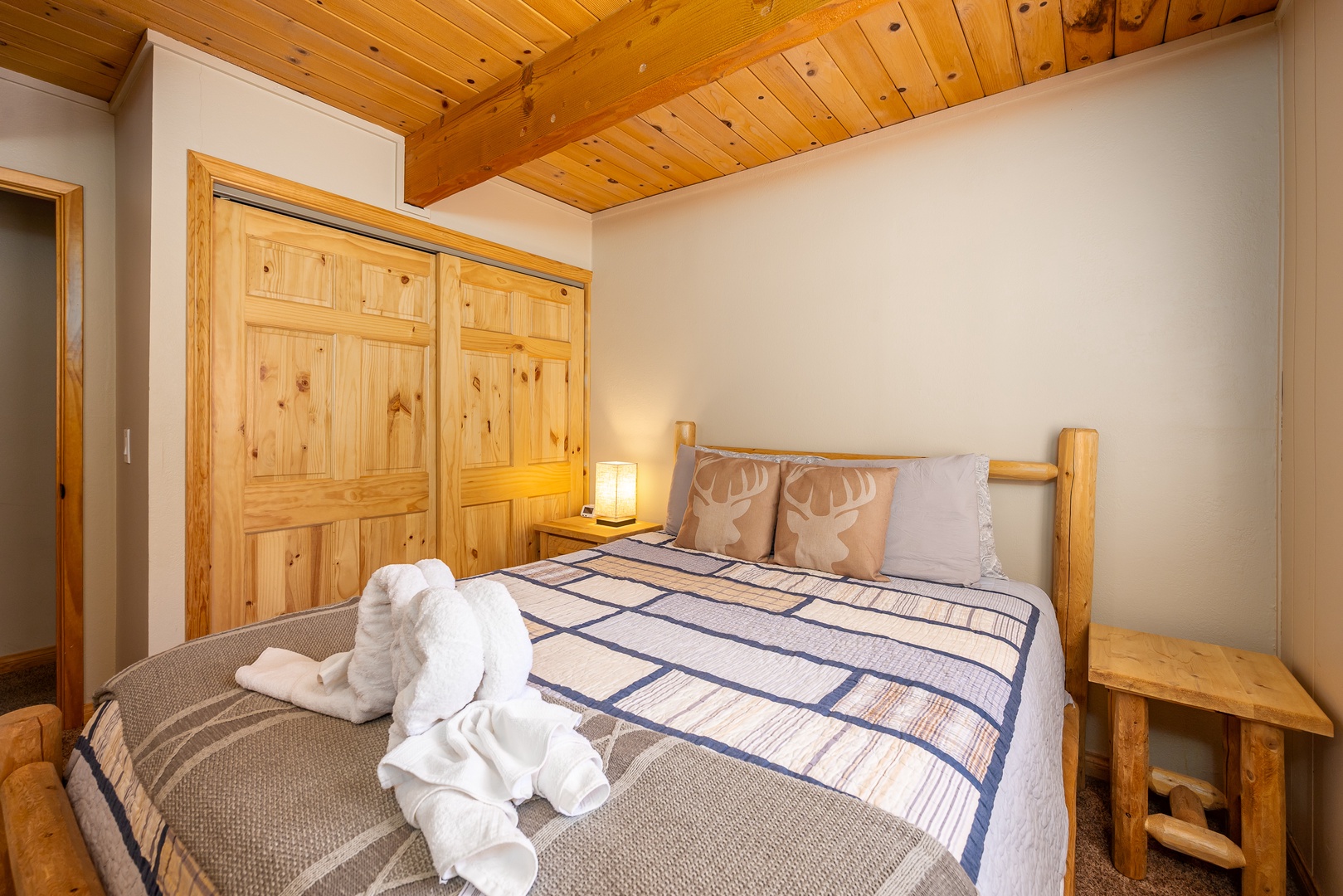Unwind in your cozy alpine retreat with warm wood beams overhead and rustic charm surrounding your comfortable bed.