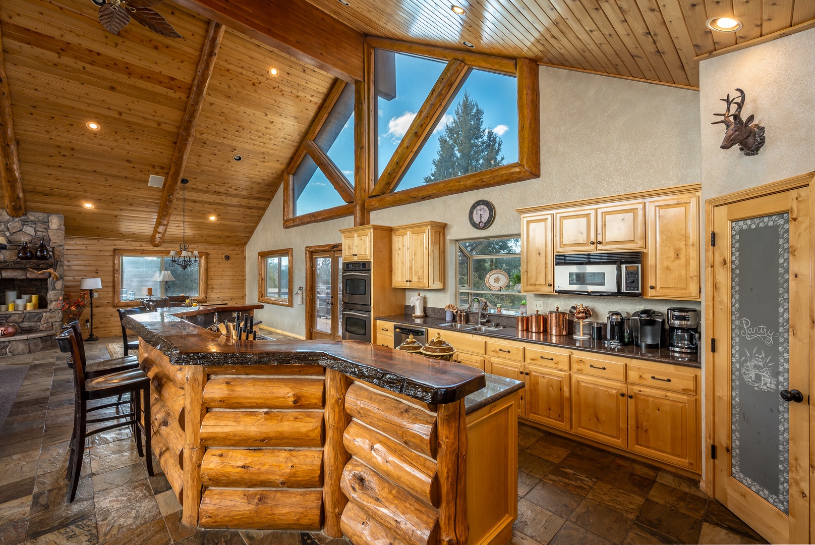 Your rustic mountain kitchen features soaring timber ceilings, granite counters, and skylights that flood the space with natural light.