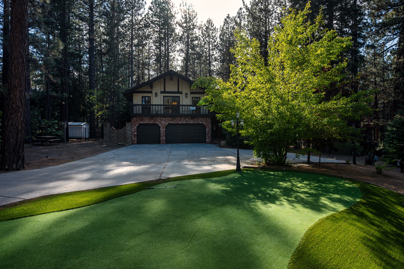 This charming mountain retreat sits nestled among towering pines, featuring a private putting green and ample parking for your woodland getaway.