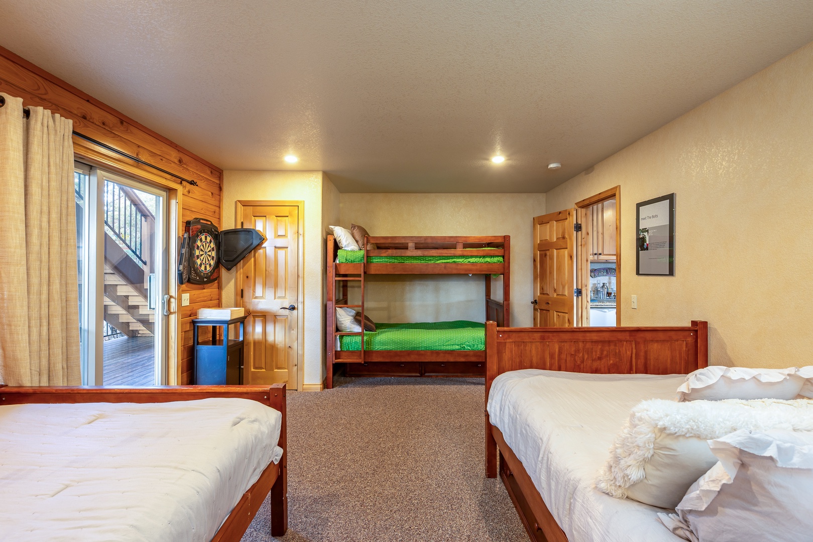 Your spacious bedroom features twin beds and a fun bunk bed, perfect for families. Enjoy the dartboard and warm wood accents.