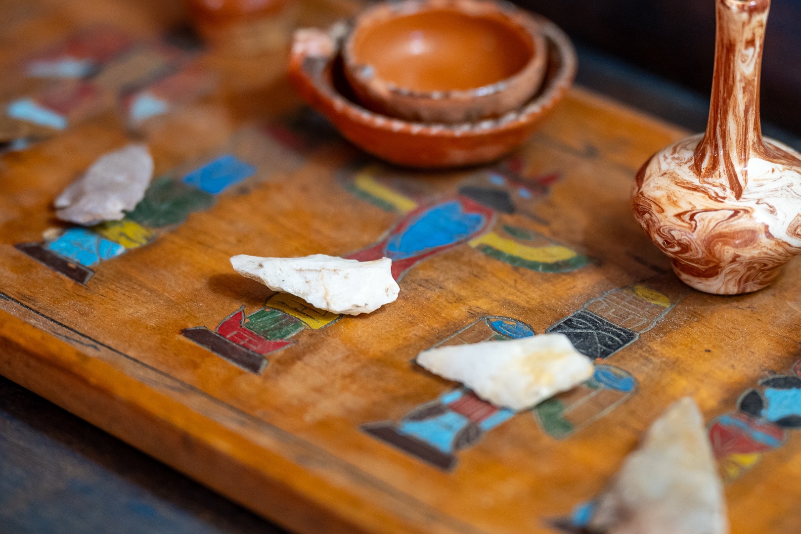 Handcrafted pottery and decorative artifacts displayed on a beautifully inlaid wooden board, showcasing the artistic character and cultural touches of your rental home.