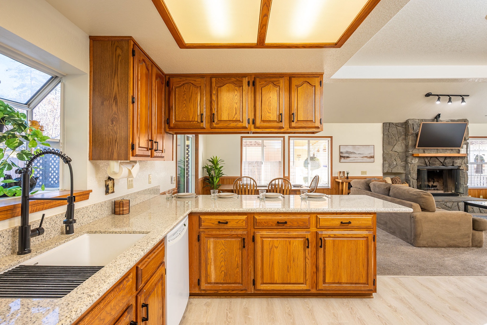 Your fully equipped kitchen  opens to the dining area and a cozy living area with stone fireplace.