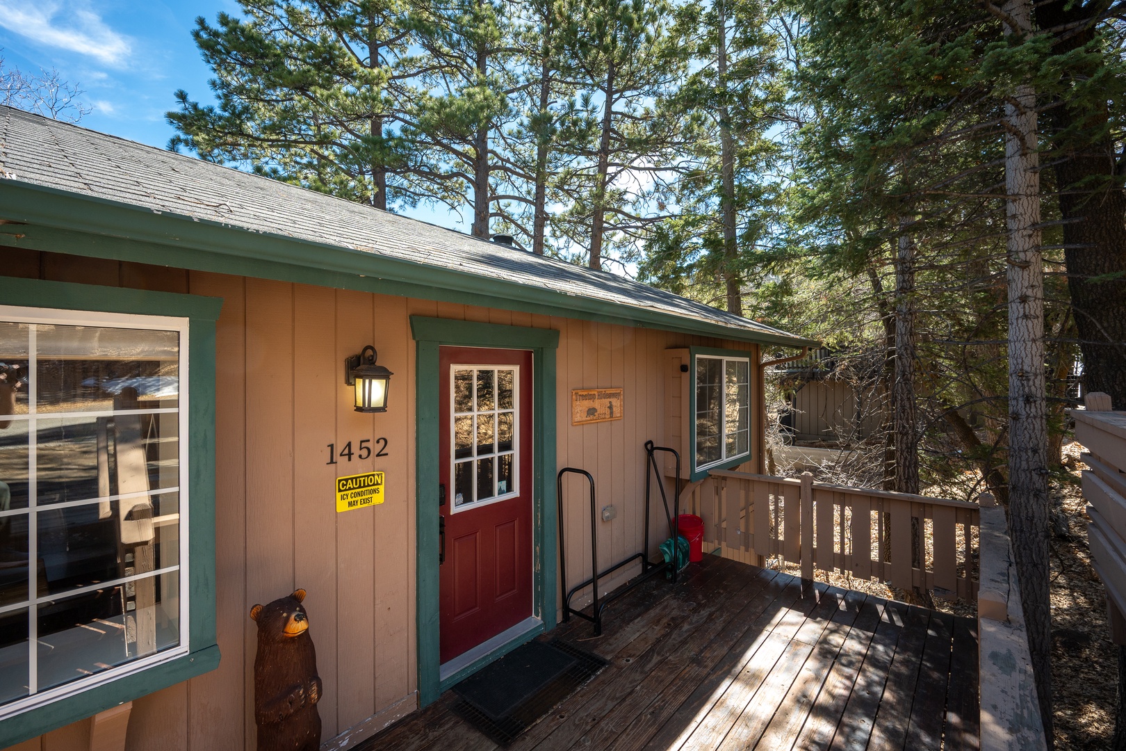 Charming mountain cabin entrance with rustic charm, nestled among towering pines in a peaceful forest setting.
