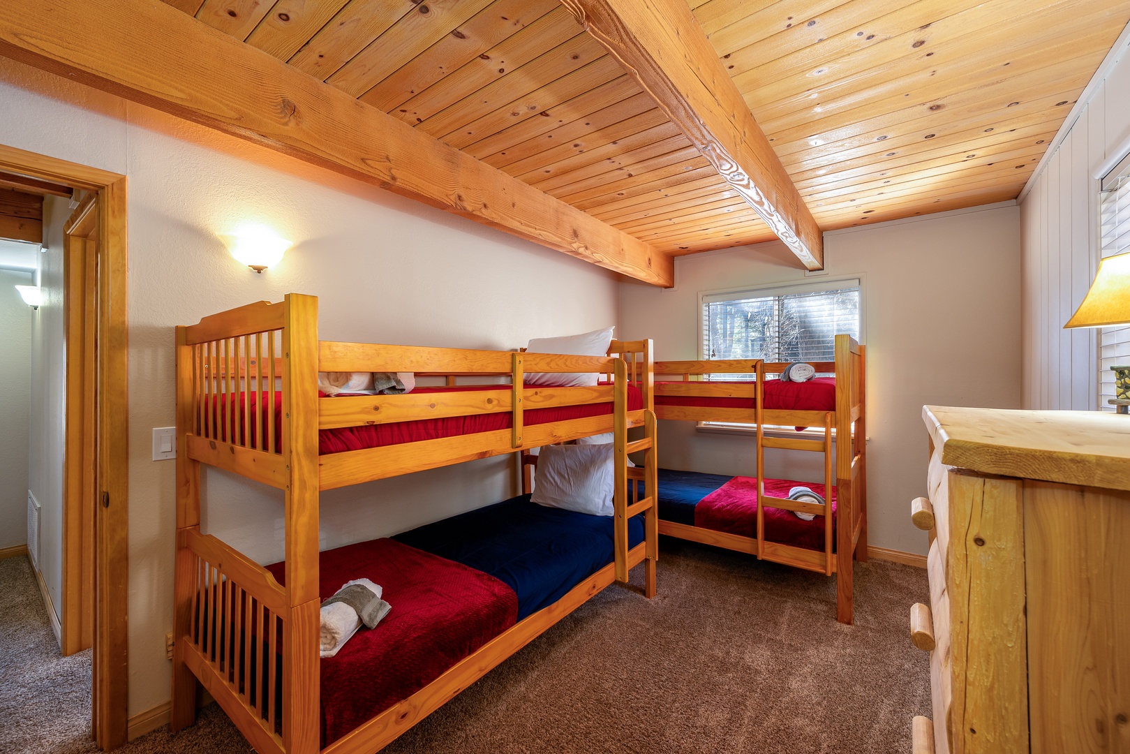 Your alpine bunk room features sturdy wood-beamed ceilings and cozy beds with crisp linens, perfect for family adventures.
