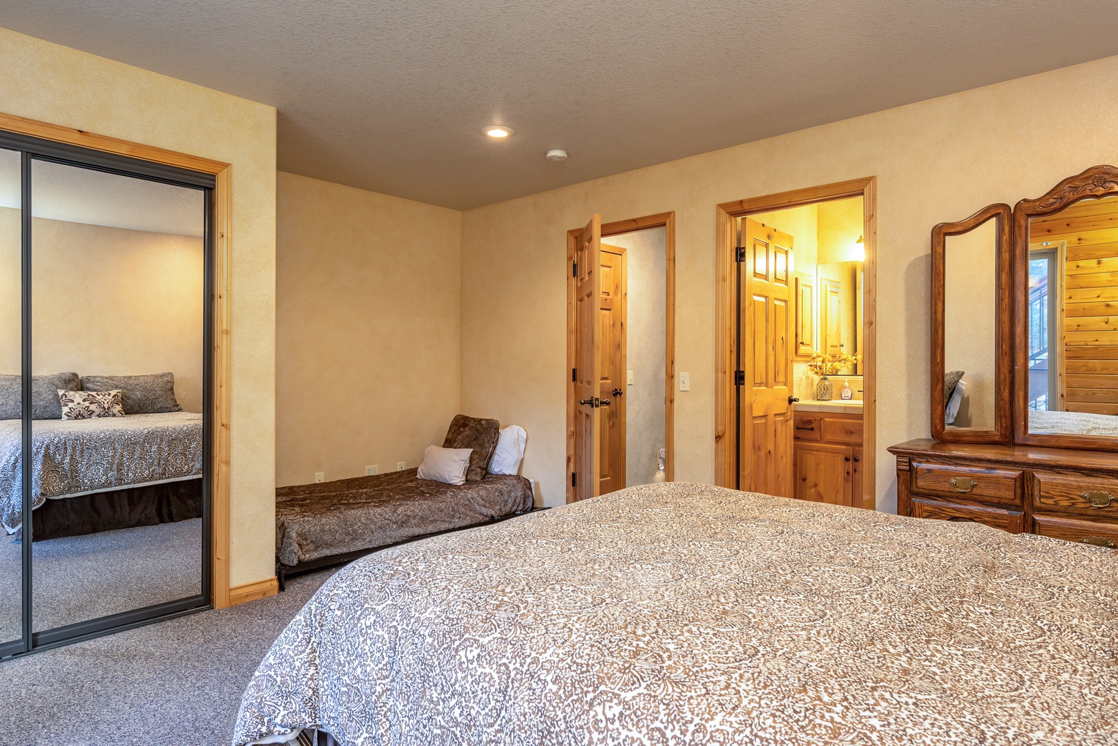 Unwind in your spacious bedroom featuring elegant wood furnishings, mirrored closets, and an ensuite bathroom for complete comfort and convenience.