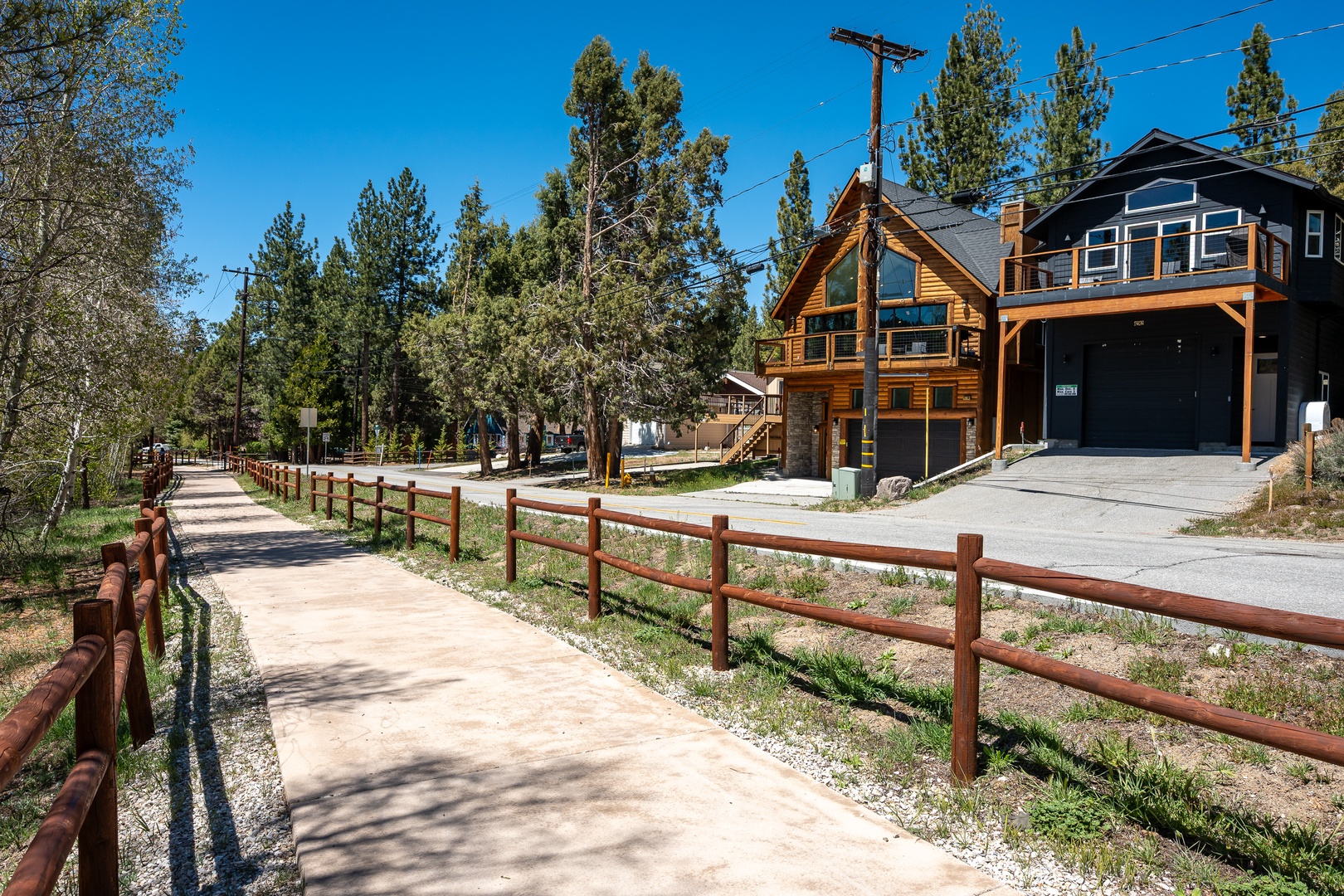 This charming mountain cabin is nestled in a peaceful neighborhood surrounded by tall pines, with a scenic walking path just steps from the front entrance—perfect for exploring the local area.