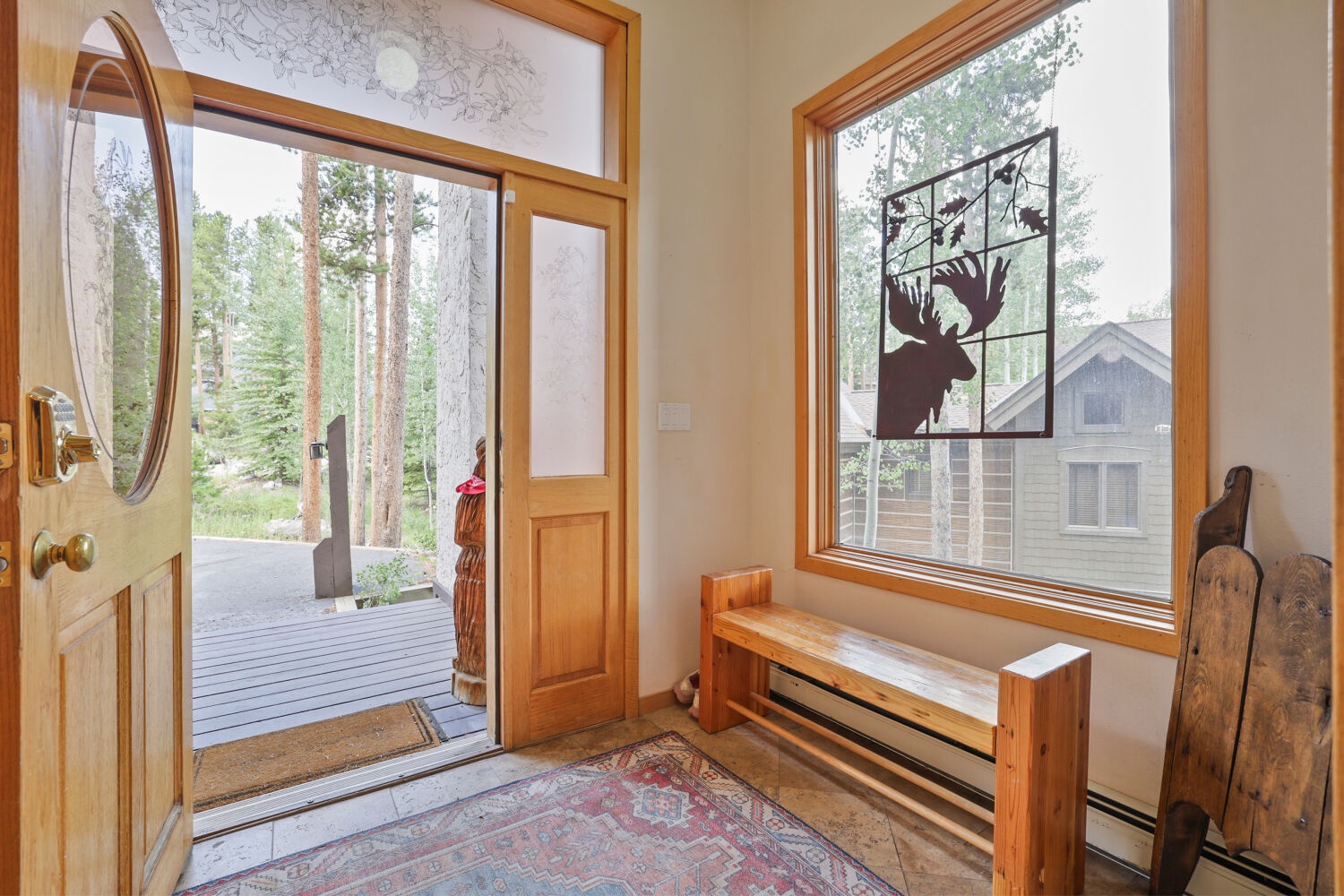 The welcoming entryway opens to towering pine trees and mountain views, setting the tone for a serene alpine escape.