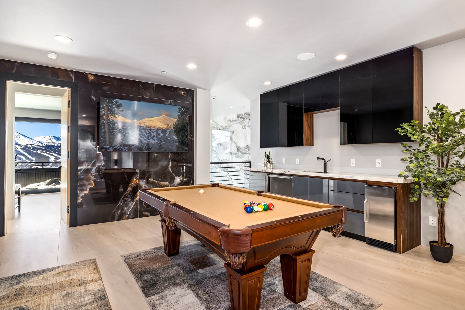Challenge friends to pool while enjoying your modern kitchen and mountain views through floor-to-ceiling windows.