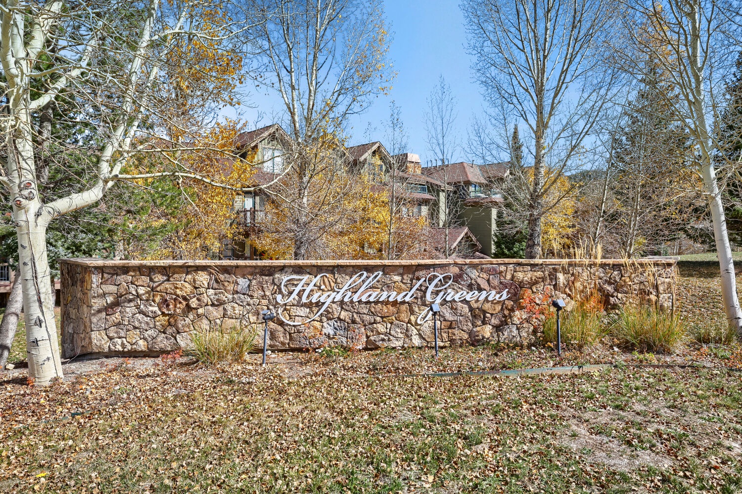 Highland Greens entrance marker set among autumn aspens and evergreens, welcoming guests to this mountain retreat.