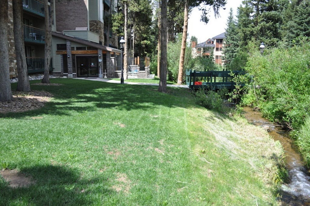 Property overlooks a peaceful creek flowing through mature trees and well-maintained grounds in this tranquil mountain setting.