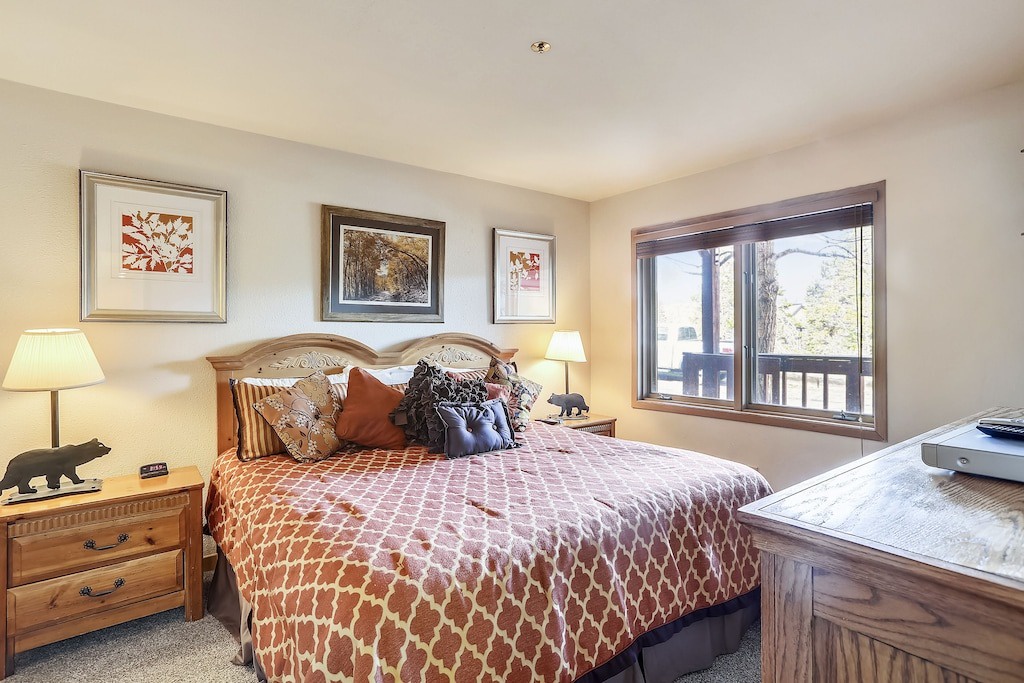 Your cozy bedroom retreat features a plush bed with warm earth tones and mountain views through your private window.