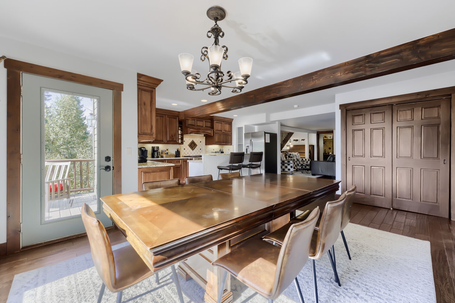 Gather around the elegant dining table where natural light pours in through the glass door, inviting you to enjoy memorable meals with loved ones in this warm, open-concept space.