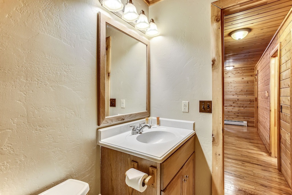 Refresh in your private bathroom featuring warm wood vanity and modern amenities, perfectly lit for your comfort.