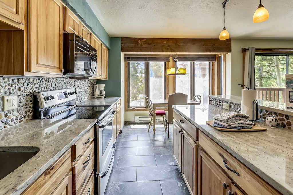 Your spacious kitchen features granite countertops, warm wood cabinetry, and stone backsplash creating the perfect space for memorable meals.