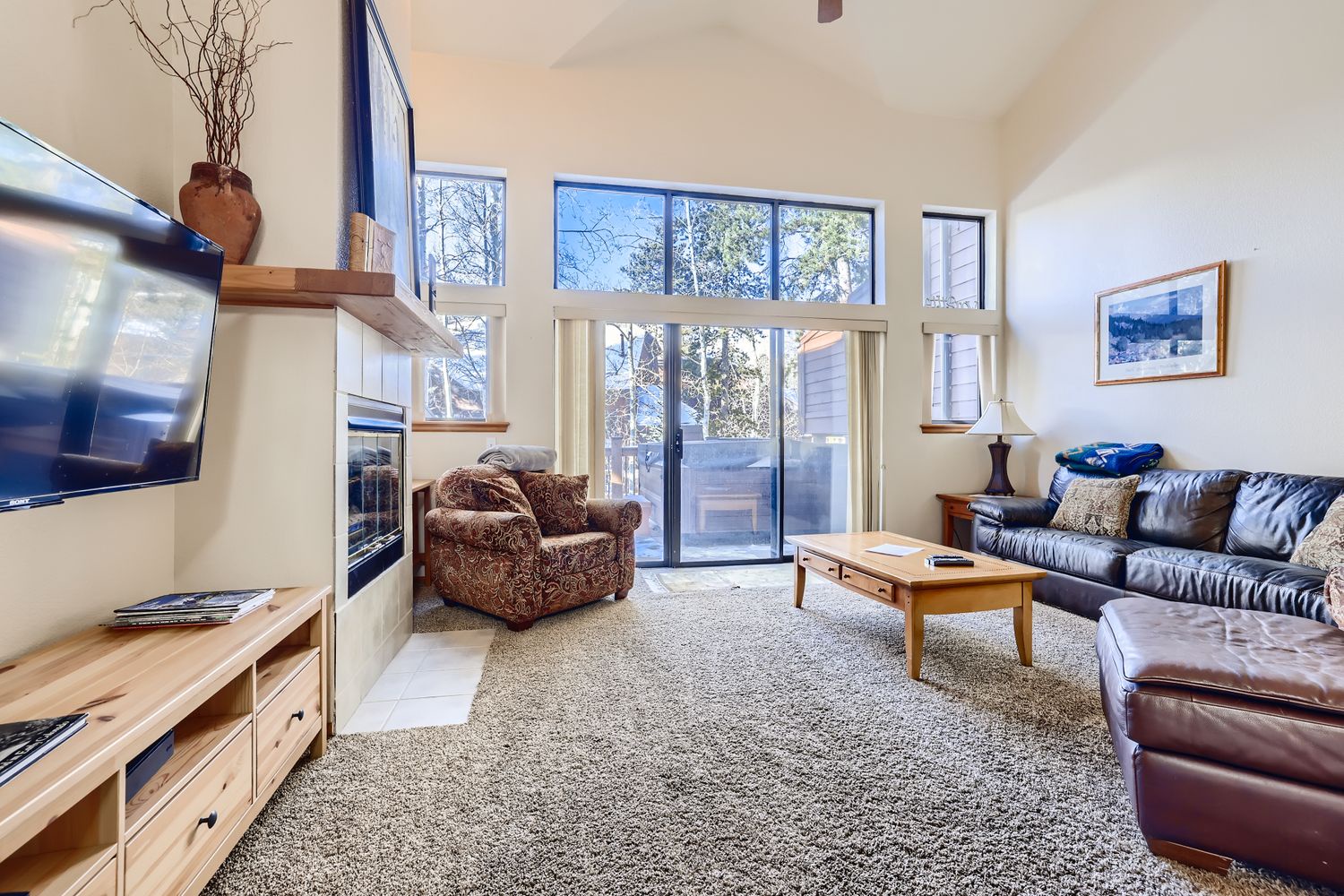 Sink into plush leather seating while enjoying mountain views through expansive windows in this bright, airy living space.
