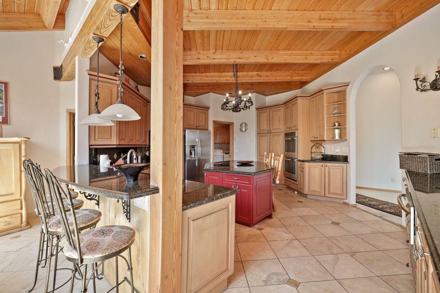 Gather around the breakfast bar or prep your favorite meals in this spacious, light-filled kitchen. Vaulted wood ceilings, granite counters, and stainless appliances make cooking feel like a mountain retreat experience.
