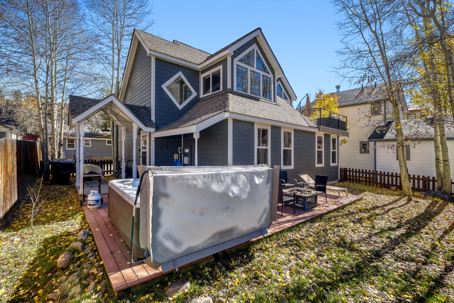 This charming mountain retreat features distinctive architecture with cathedral windows and an inviting outdoor deck complete with hot tub, BBQ area, and patio seating—perfect for your alpine getaway.
