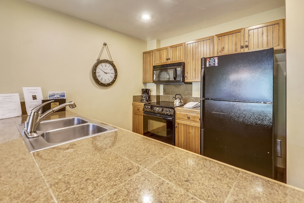 Your fully equipped kitchen features granite countertops, stainless steel appliances, and warm wood cabinetry for comfortable meal preparation.