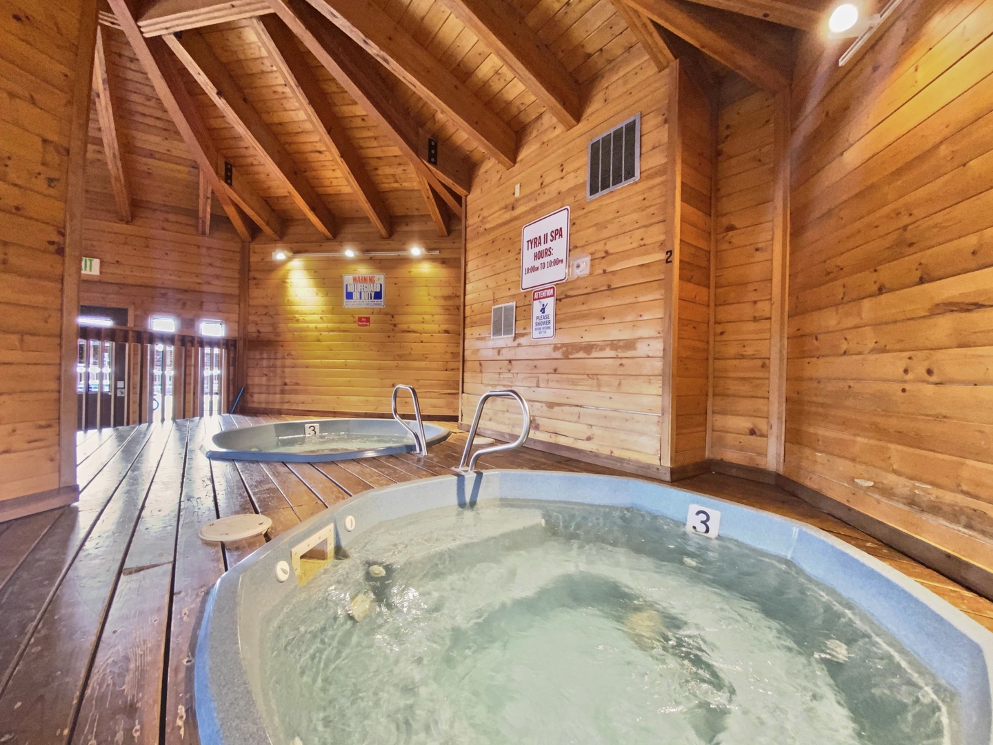 Unwind in the rustic charm of the wood-paneled spa with bubbling hot tubs that invite pure relaxation.