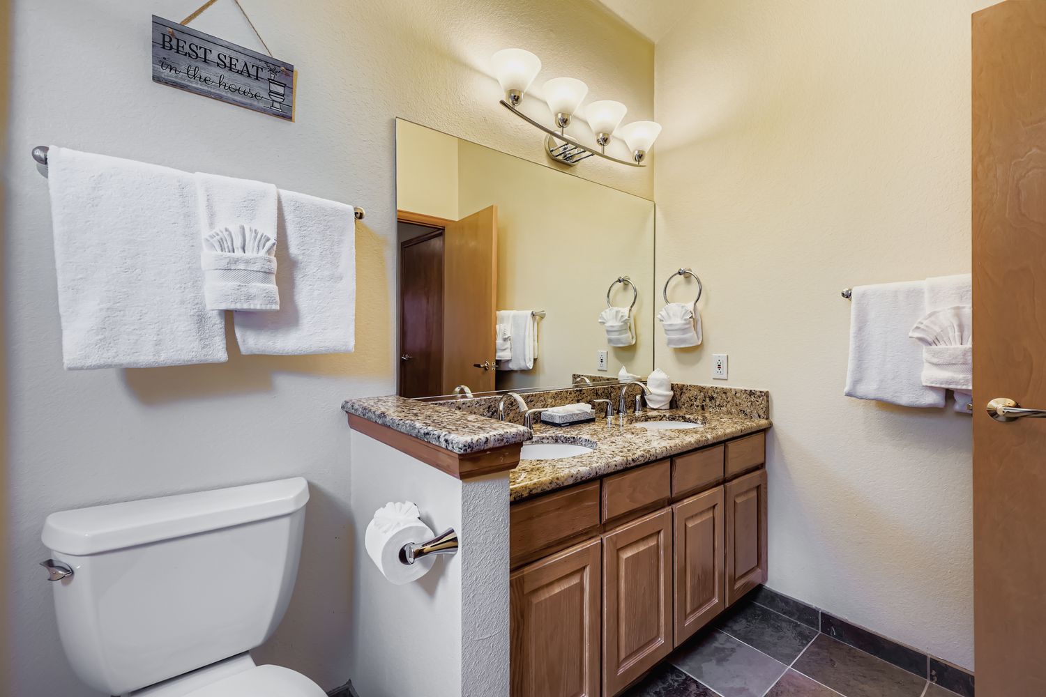 Step into your beautifully appointed bathroom with granite countertops, dual sinks, and soft lighting for your morning routine.