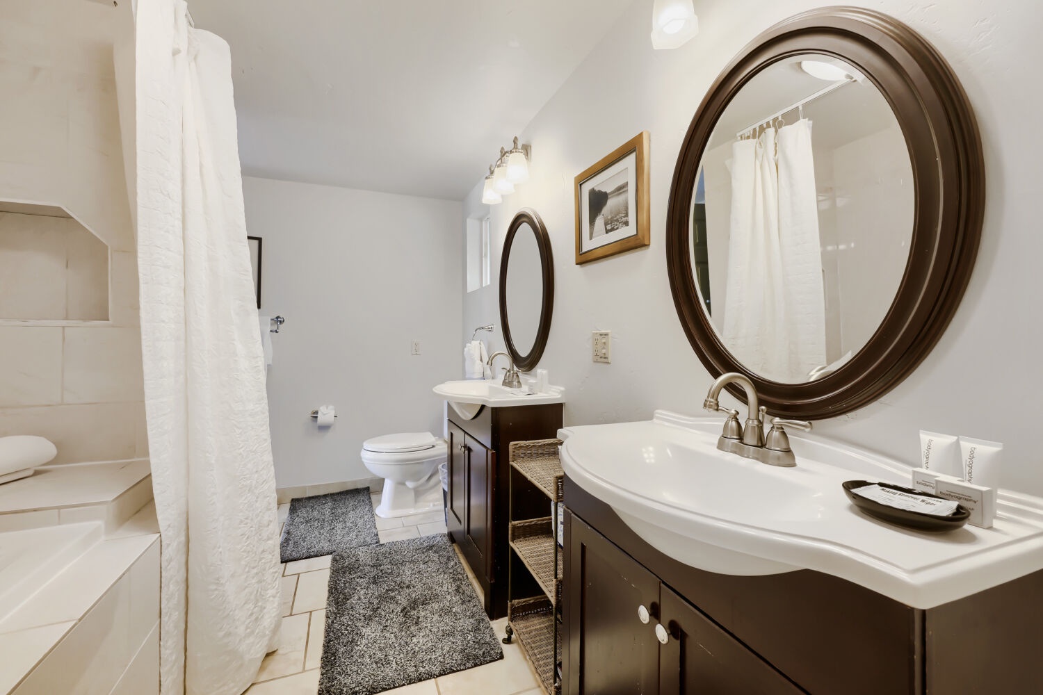 Step into your private bathroom with dual vanities and fresh towels, where statement mirrors add a touch of elegance to your morning routine.