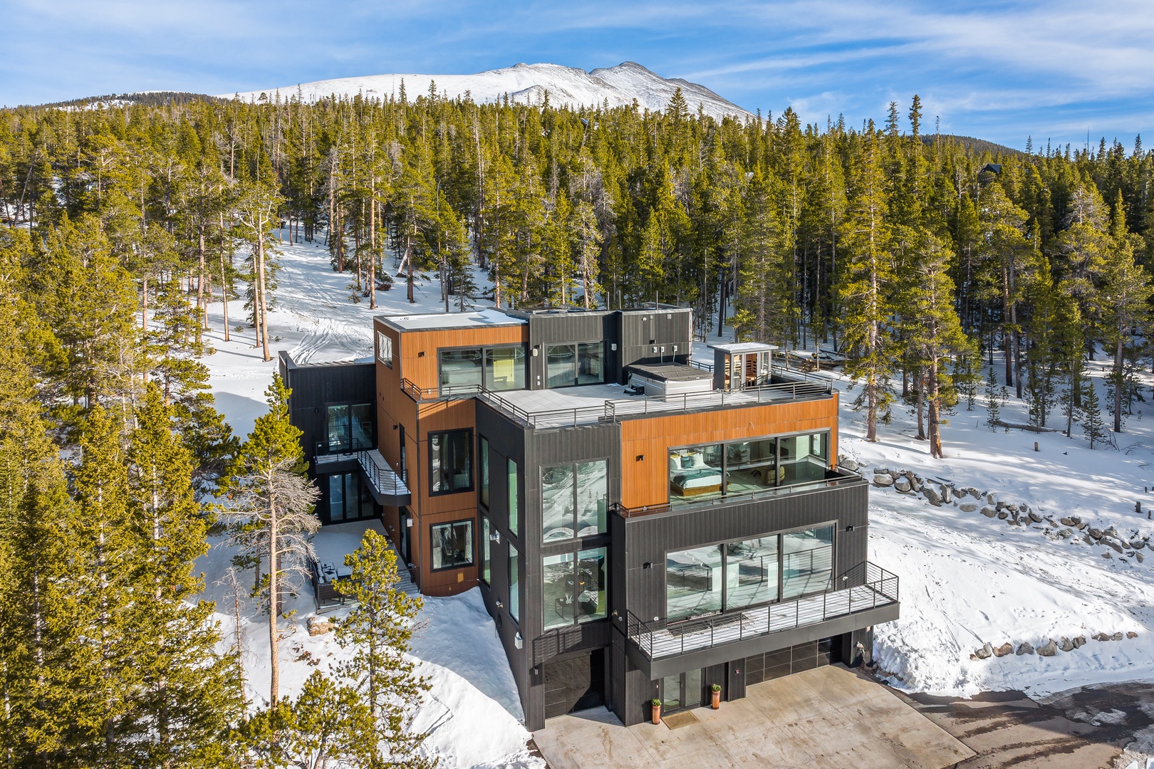 Modern mountain retreat nestled in snowy alpine landscape with panoramic mountain views and ski-in access.