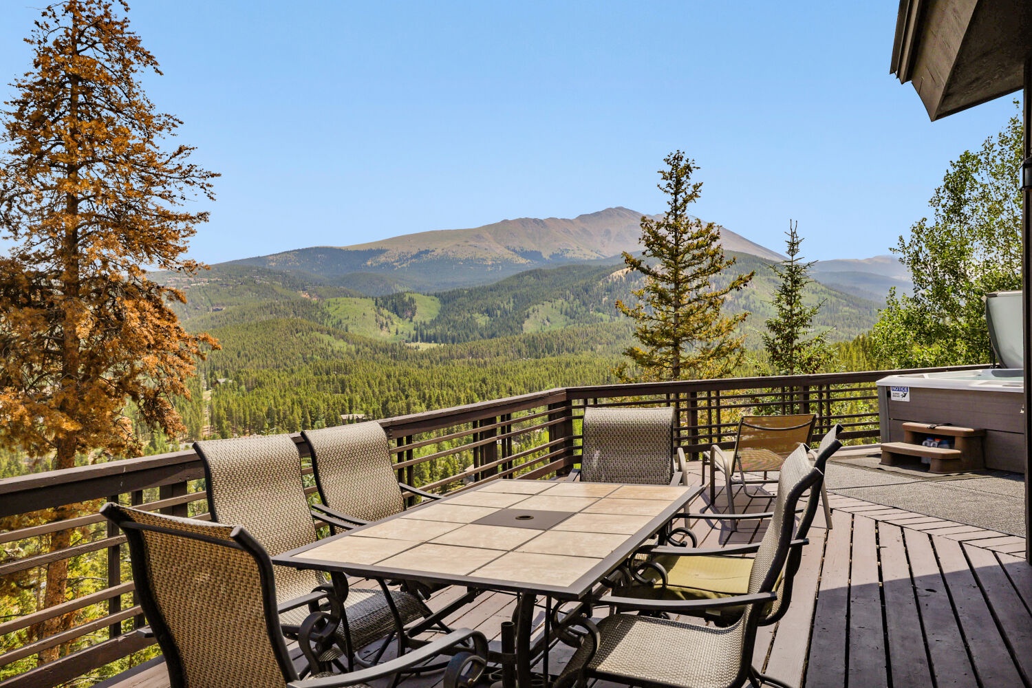 Unwind on your private deck with breathtaking mountain vistas, a hot tub for soaking under the stars, and a dining table perfect for al fresco meals surrounded by autumn colors and forest views.