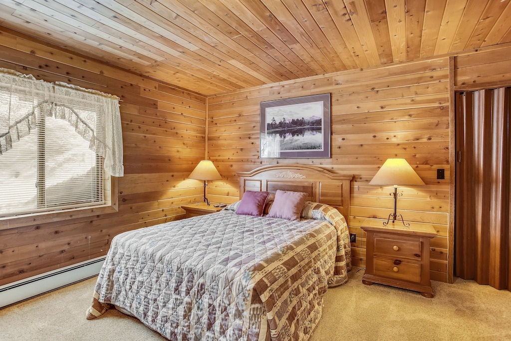 Drift off peacefully in your cozy log cabin bedroom with warm wood walls and soft lighting creating the perfect mountain retreat atmosphere.
