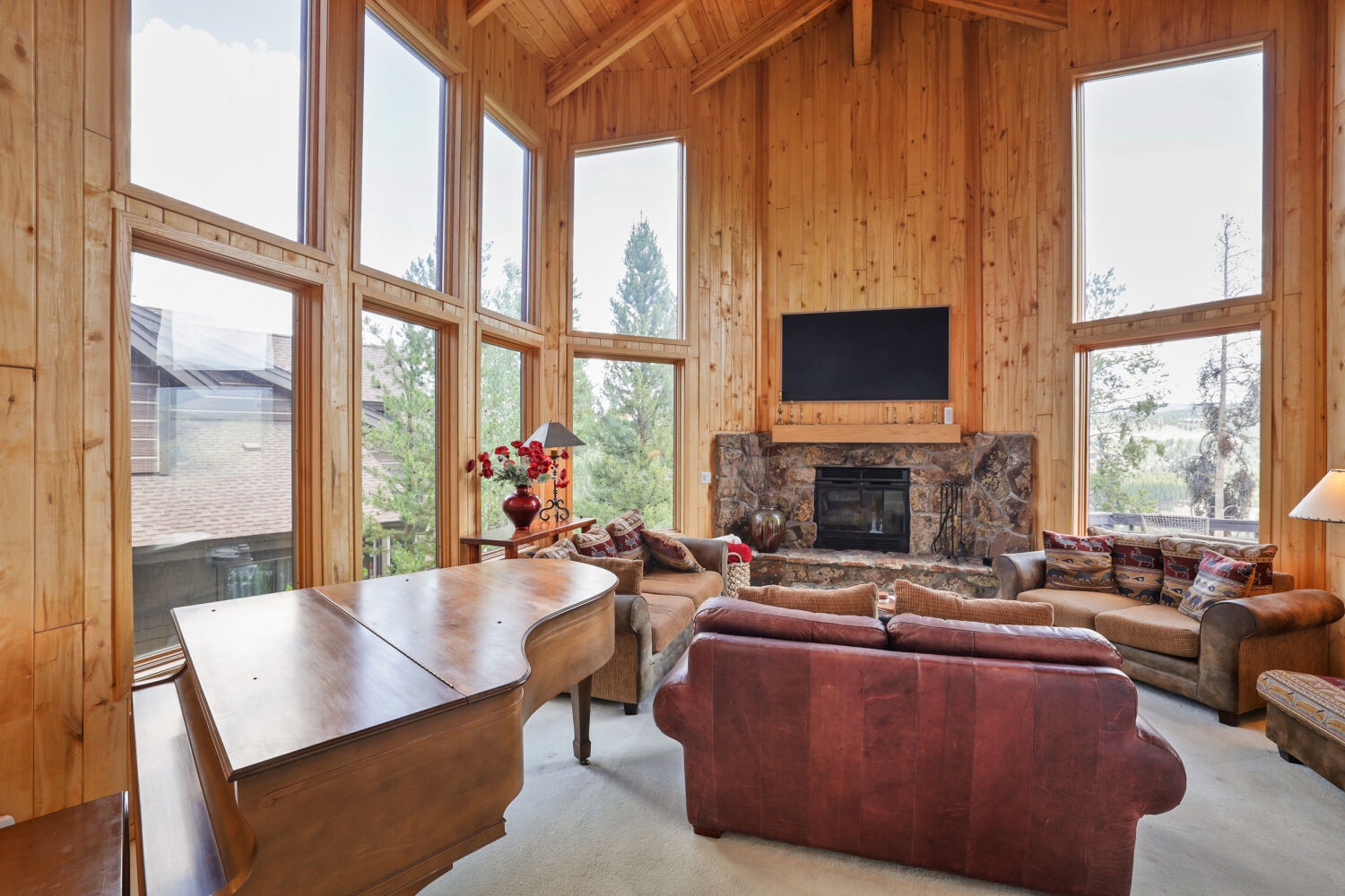 Warm wood walls and soaring ceilings frame your mountain retreat, where you'll gather by the stone fireplace beneath windows that bring the pines right inside.