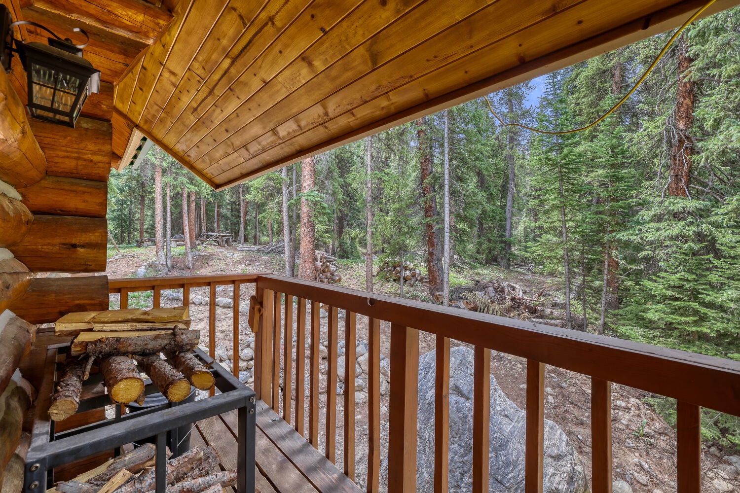 Your private covered balcony opens to stunning forest views, where towering pines and fresh mountain air surround you in peaceful seclusion.